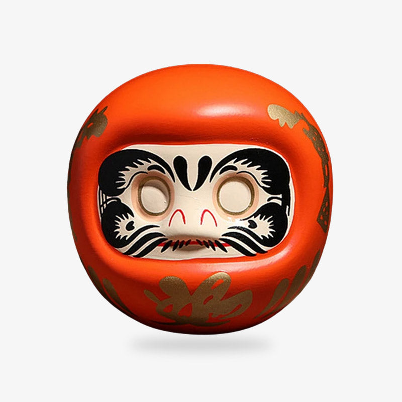 Daruma orange symbolisant l'énergie et la motivation, traditionnellement utilisé au Japon pour encourager l'enthousiasme et la détermination
