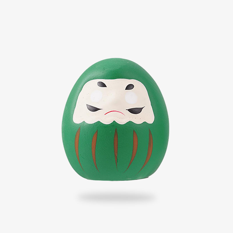 Statuette Daruma vert posée sur une étagère de décoration japonaise
