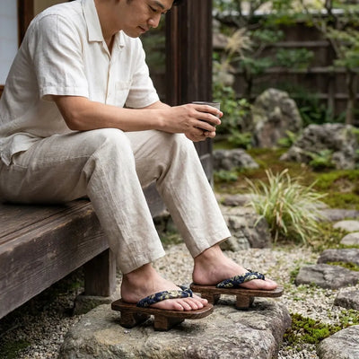 Sandale geta portée avec des chaussettes tabi blanches sur un chemin de jardin