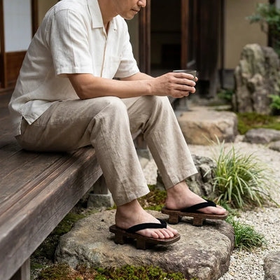 Geta portées avec des chaussettes tabi blanches dans un jardin japonais