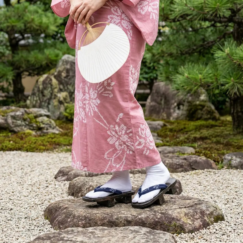 Geta femme portée avec un kimono rose dans un jardin japonais