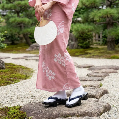 Geta porté avec un yukata dans un jardin japonais