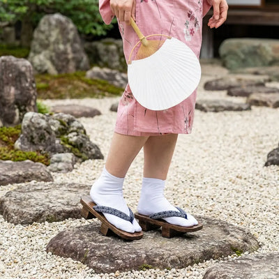 Geta Seigaiha portée avec un kimono rose dans un jardin japonais