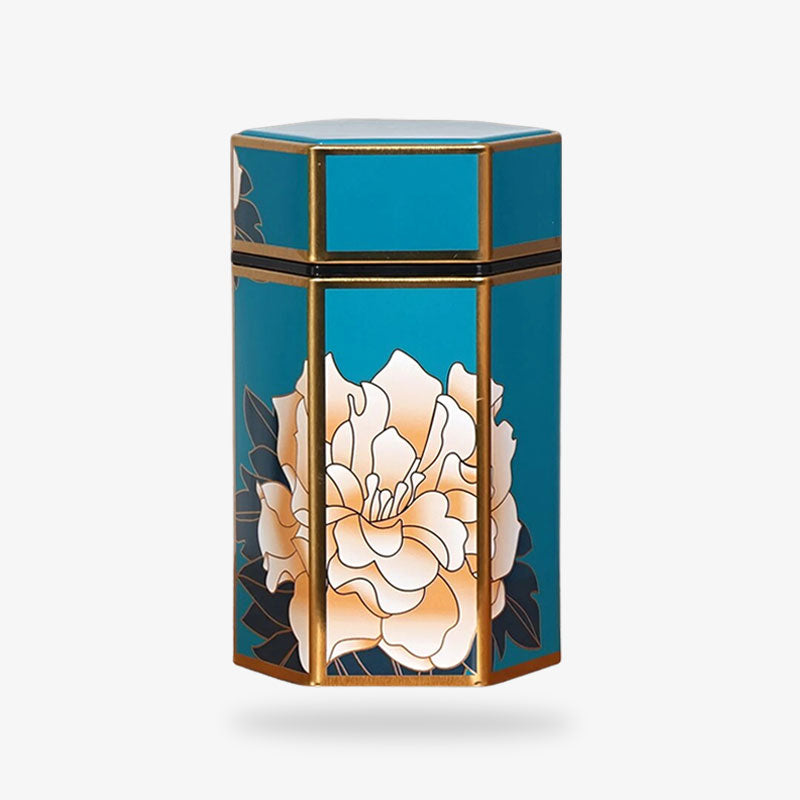 Une grande boite a the japonais de couleur bleu, en metal et avec un dessin de fleur blanch