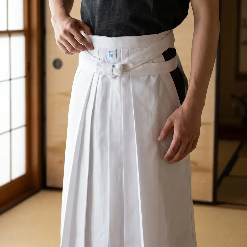 Hakama Blanc porté par un homme dans une pièce japonaise traditionnelle, vue de face