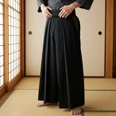 Hakama Noir porté par un homme dans une pièce japonaise traditionnelle, vue de face