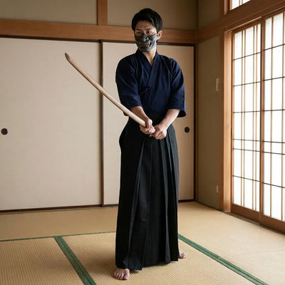 Hakama Noir porté par un homme dans une pièce japonaise traditionnelle, vue de face