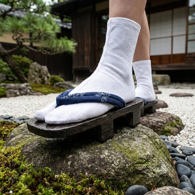 Gros plan sur la lanière hanao bleu marine à motif blanc sur des sandales geta japonaises