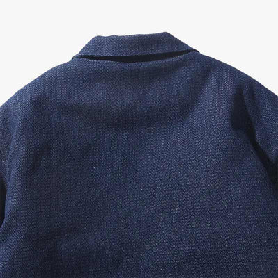 Cette image montre la qualité du tissu d'un haori bleu foncé, au style minimaliste et aux tons indigo, idéal pour des looks raffinés et polyvalents
