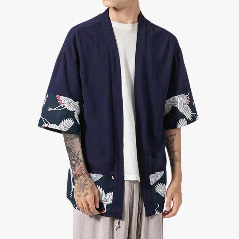 Ce kimnoo haori homme traditionnel est de couleur bleu marine. Des motifs de grues tsuru sont imprimés sur l'extremité de la veste japonaise homme