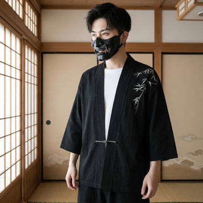 Homme portant un haori kimono noir à motif bambou dans une pièce japonaise