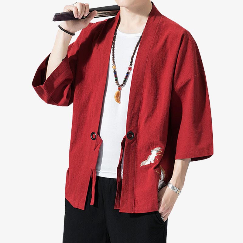 Un homme japonais est habillé avec une veste haori traditionnel rouge. La veste en coton est ouverte et brodé d'un motif de grue japonaise