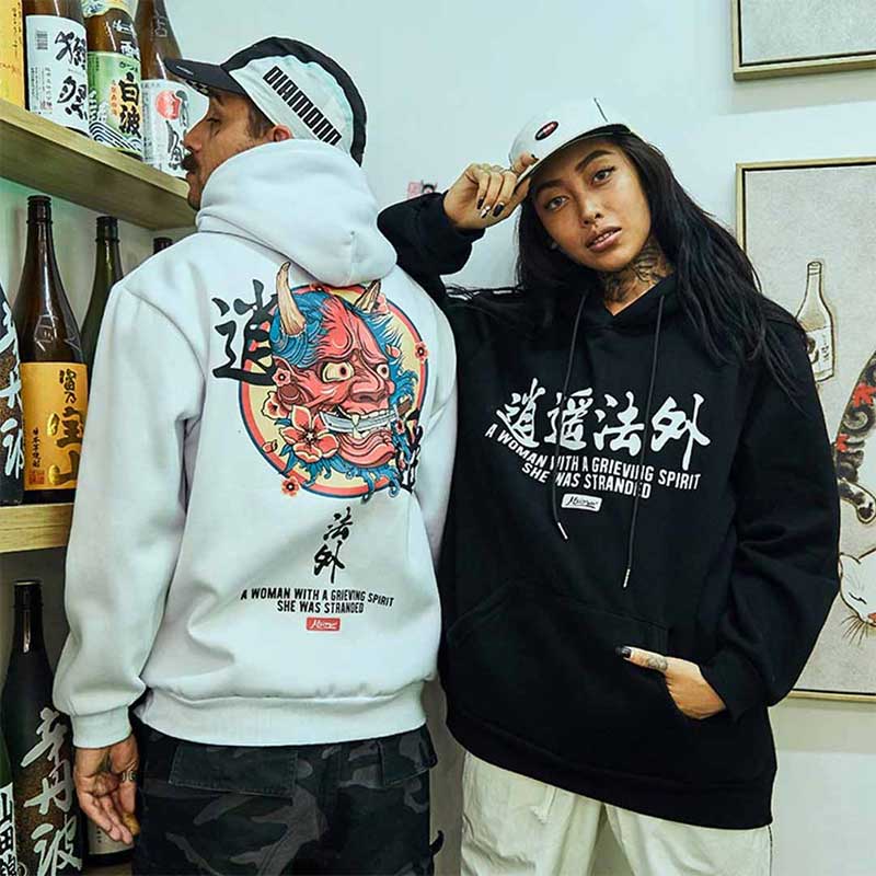 Un homme et une femme portent un hoodie démon Oni, coloris blanc et noir, motif kanji et visage de démon irezumi