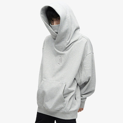 Un homme est debout et porte un Hoodie japon minimaliste, en coton gris de qualité, idéal pour un look épuré et moderne inspiré du Japon d' Harajuku