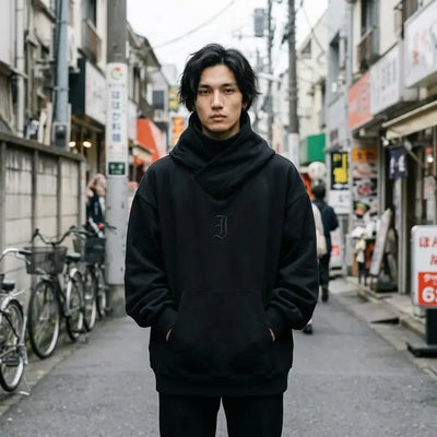 Hoodie noir style Harajuku avec un col cheminée croisé, porté oversize avec les mains dans la poche kangourou
