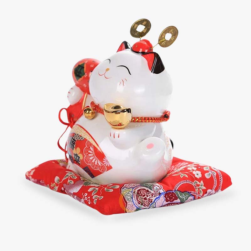 Le japanese maneki neko lucky fortune est fabriquée en céramique. La couleute du chat japonais porte-bonheur est blanc et rouge. C'est un chat de la chance posé sur un coussin rouge