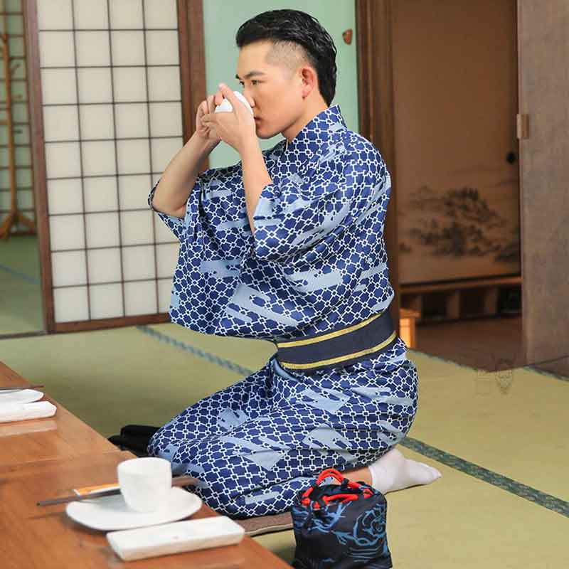 Un homme japonais est assi sur un tatami et participe à la cérémonie du thé