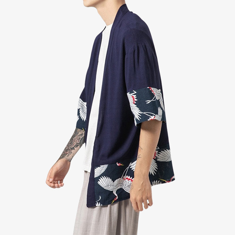 un homme est habillé avec un kimono haori japonais de couleur bleur marine avec des motifs d'oiseaux tsuru