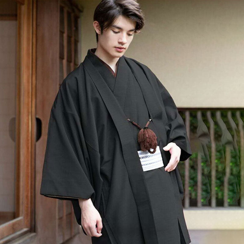 Un homme est habillé avec un kimono samurai japonais. Une ceinture Obi blanche attache le kimono japonais