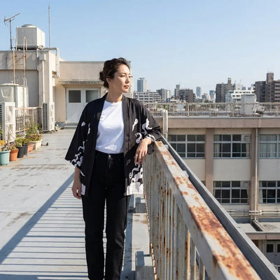 Kimono tigre streetwear porté appuyé contre une rambarde de toit au-dessus de la ville