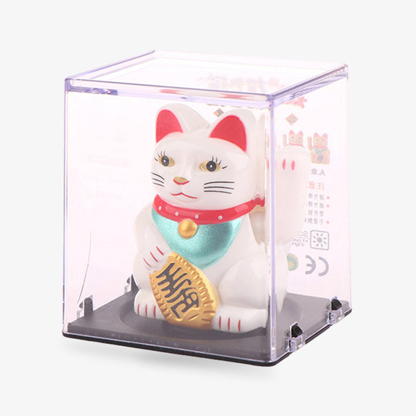 Le lucky cat maneki nejo est emballé dans une boite en plastique carrée. Le chat porte-bonheur est de couleur blanche avec l'interieur des oreilles de couleurs rouges. Il a un collier rouge et il tien une pièce Koban dans la patte. Sa seconde patte gauche attire la chance et la bonne fortune