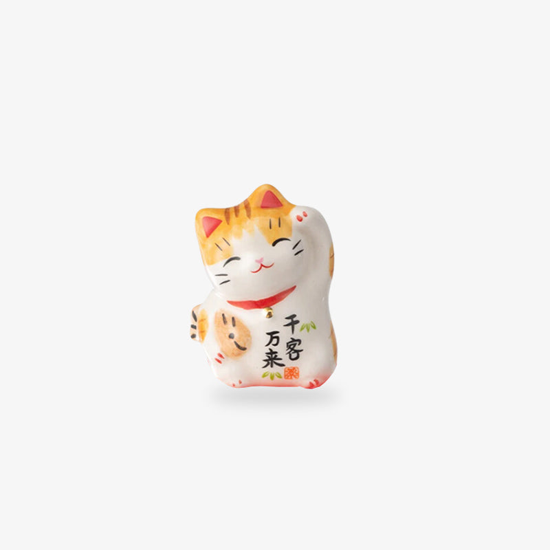 un chat maneki neko droit blanc qui leve sa patte gauche pour attirer la chance et la richesse
