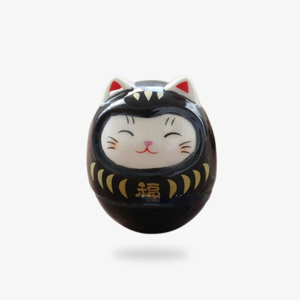 Une statuette japonaise maneki neko noir fabriqué en matière céramique en forme de tête de chat mignon