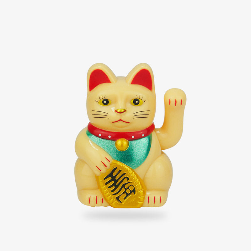 le maneki neko traditionnel est de couleur dorée. Sa patte gauche est levée pour attirer la bonne fortune et inviter à entrer. Il tient dans la main une pièce Koban