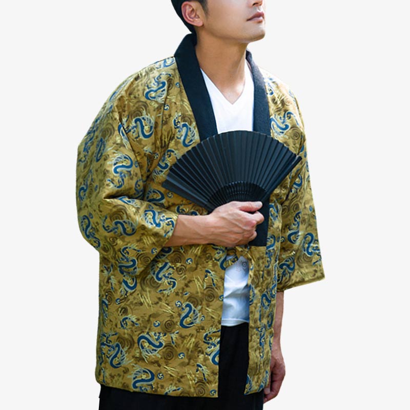 un homme est habillé avec un manteau japonais aux motifs de dragons sur le tissu. Il tient dans la main un éventail pliant type Sensu de couleur noir