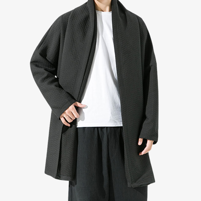 Un homme se tient devout et est vêtu d'un manteau japonais noir