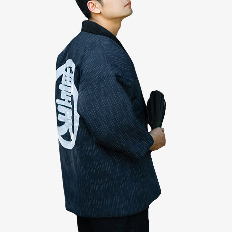 Un homme de dos est habillé avec un manteau japonais traditionnel hanten bleu