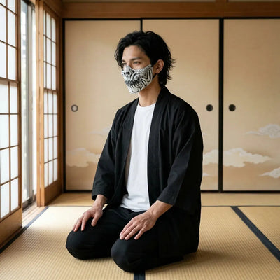 Masque crâne Shinigami vu de profil, avec la joue craquelée et les dents squelettiques, porté à genoux sur tatami.