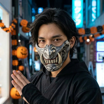 Masque oni demi-visage argente avec crocs ivoire porte la nuit pour Halloween, neon bleu de Tokyo en arriere-plan