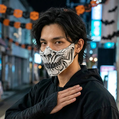 Masque crâne blanc os porté la nuit pour Halloween, néons bleus de Tokyo en arrière-plan.