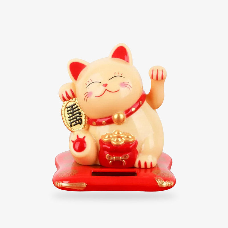 Ce chat neko maneki est de couleur jaune, doré. Ce chat japonais porte-bonheur tient un koban doré dans sa patte droite. Sa patte gauche est levé. Il y a un sac de pièce s d'or devant lui. Il a un collier rouge avec une clochette autour du cou et l'interieur de ses oreilles est aussi rouge