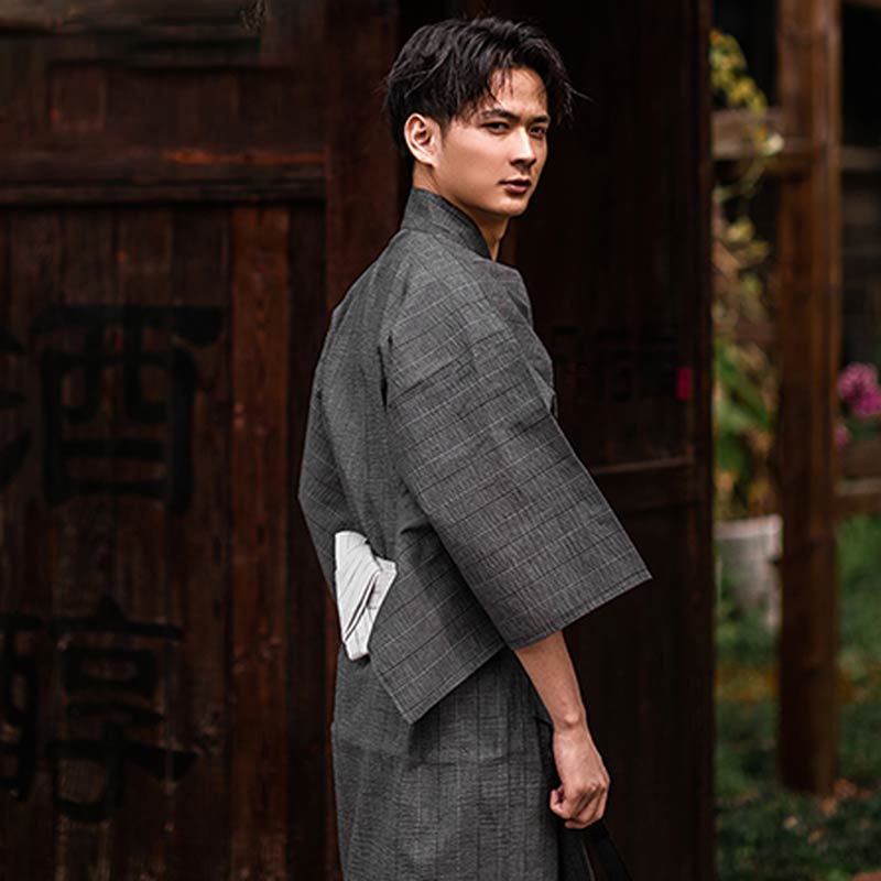 Un homme japonais est habillé avec un yukata kimono à carreaux et une ceinture Obi blanche