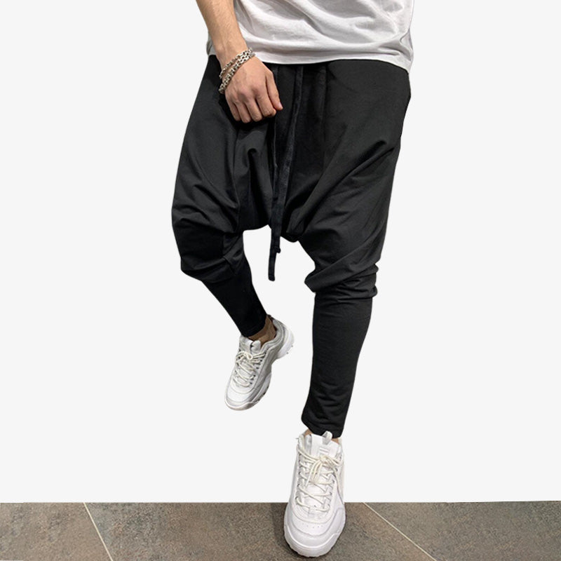 Un homme est habillé avec un pantalon streetwear jogging japonais. Le vêtement est resserré au niveau des mollets