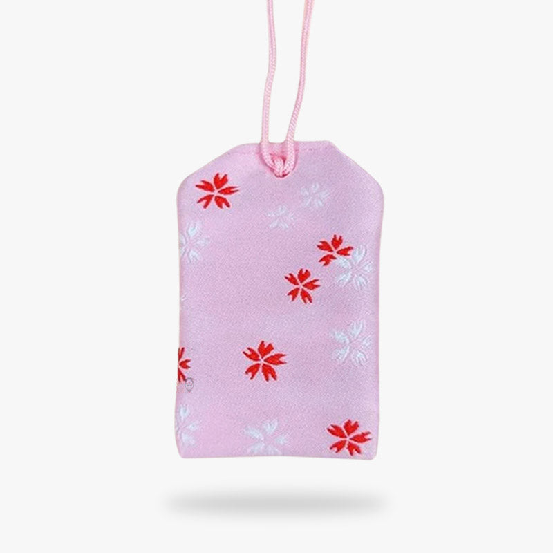 Le porte-bonheur Omamori amour a des fleurs de sakura brodé sur le tissu en coton
