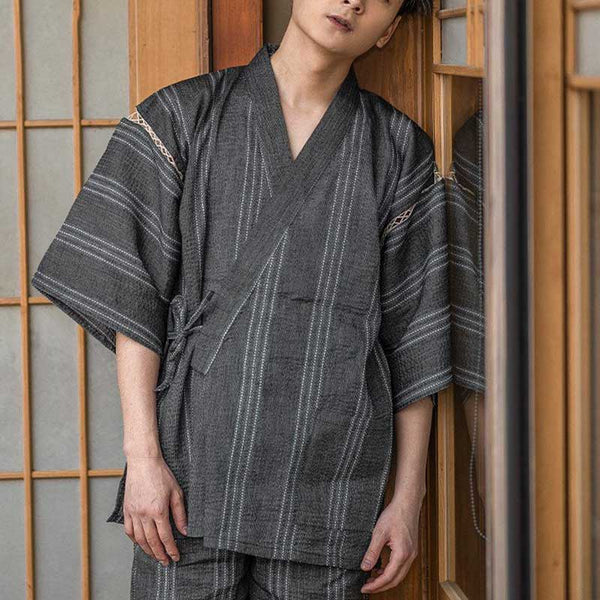 Un homme est habillé avec un pyjama Japon. Cet ensemble japonais est un Jinebi: un short et un t-shirt traditionnel