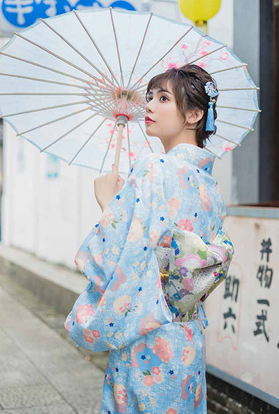 Robe kimono de style traditionnel, aux motifs floraux japonais raffinés, la femme tient un wagasa qui ajoute à l'élégance de sa tenue