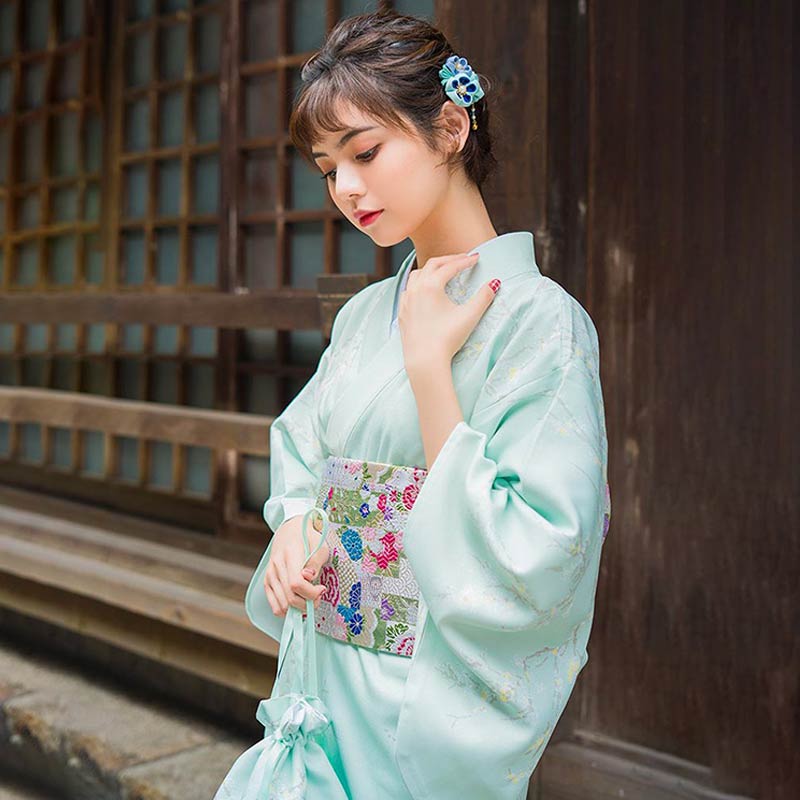 Femme portant une robe kimono blanche traditionnelle avec fleur de kanzashi 簪 dans les cheveux