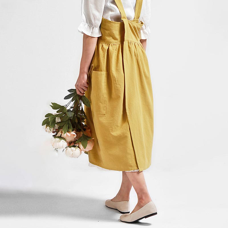 Une femme porte une robe tablier style japonais et un bouquet de fleur