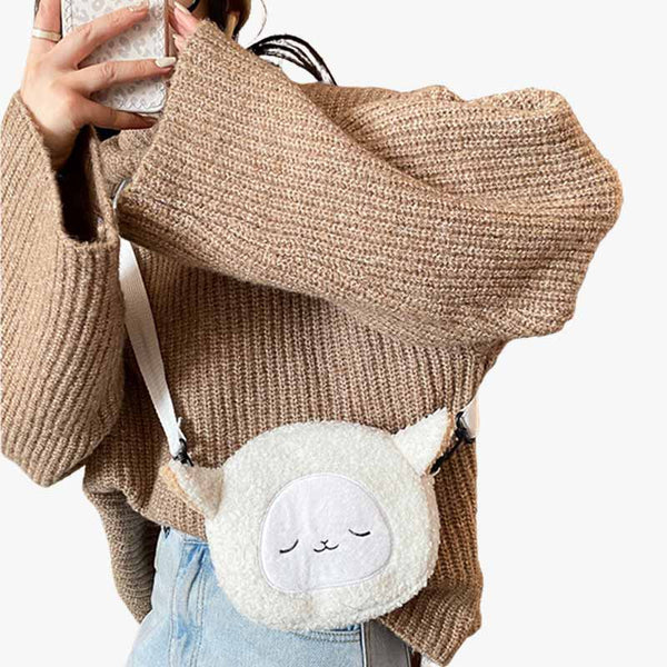 Une femme japonaise a un sac a main kawaii mignon sur l'epaule. C est un sac molletonné de couleur blanche qui ressemble à un mignon petit mouton