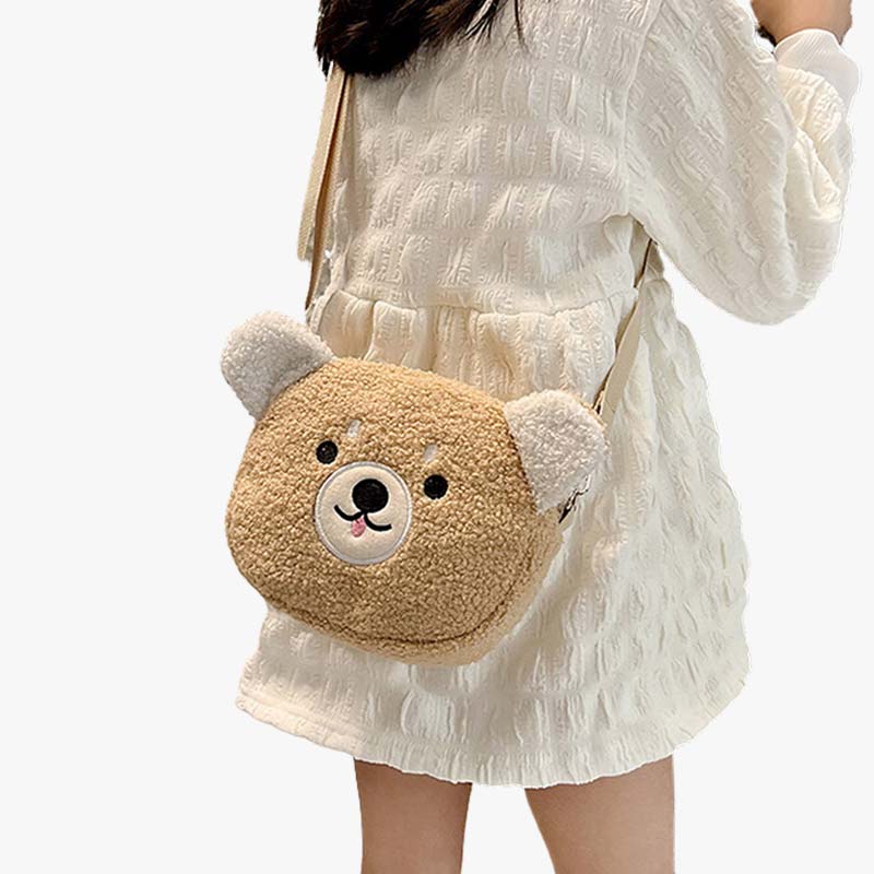 Une femme en jupe porte sur l'épaule un sac bandouliere kawaii en forme de tête d'ourson. La matière du sac est douce et de couleur Khaki