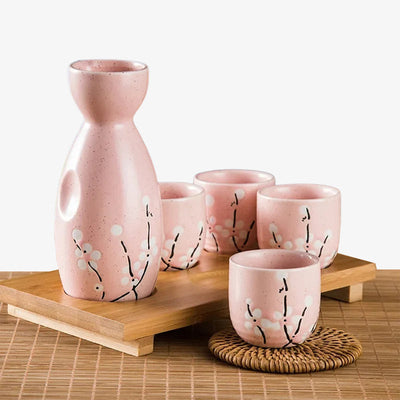 Service à saké japonais en céramique avec quatre tasses ornées de fleurs de sakura