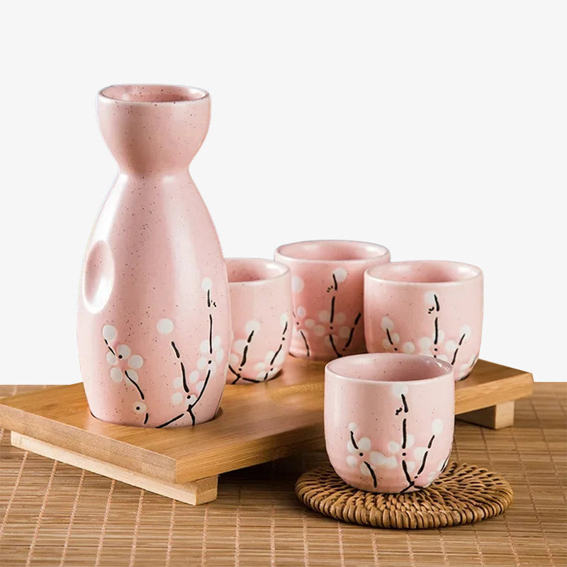 Service à saké japonais en céramique avec quatre tasses ornées de fleurs de sakura