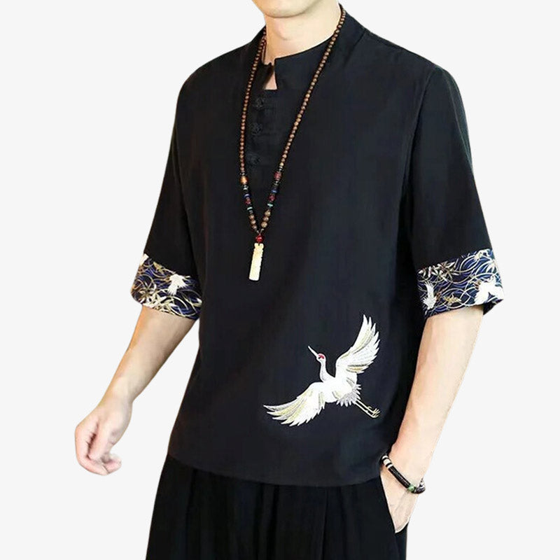 Le meilleur site pour un t-shirt japonais. Un homme est habillé avec un t-shirt traditionnel noir et brodé avec un motif d'oiseau japonais (tsuru)