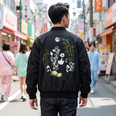 Personne portant un sukajan noir avec motifs panda dans la rue