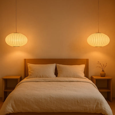 Chambre avec tête de lit en bois, linge de lit beige et deux luminaires japonais modernes diffusant une lumière chaleureuse