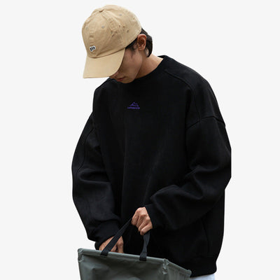Sweat japonais noir uni à col rond et manches longues, en spandex et polyester, porté par un homme avec une casquette et un sac